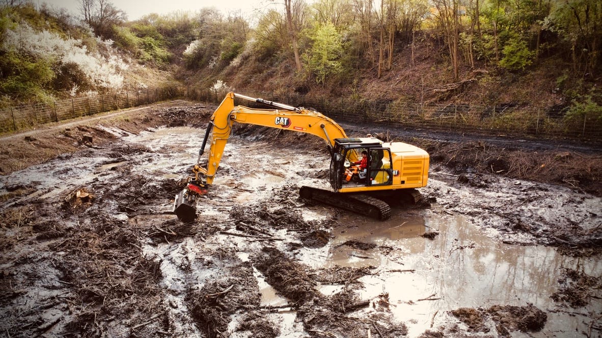 Caterpillar-Bagger auf Rodungs-Baustelle
